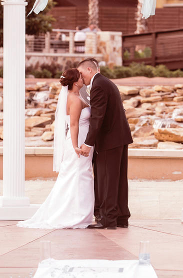 Bride and groom kissing in wedding ceremony